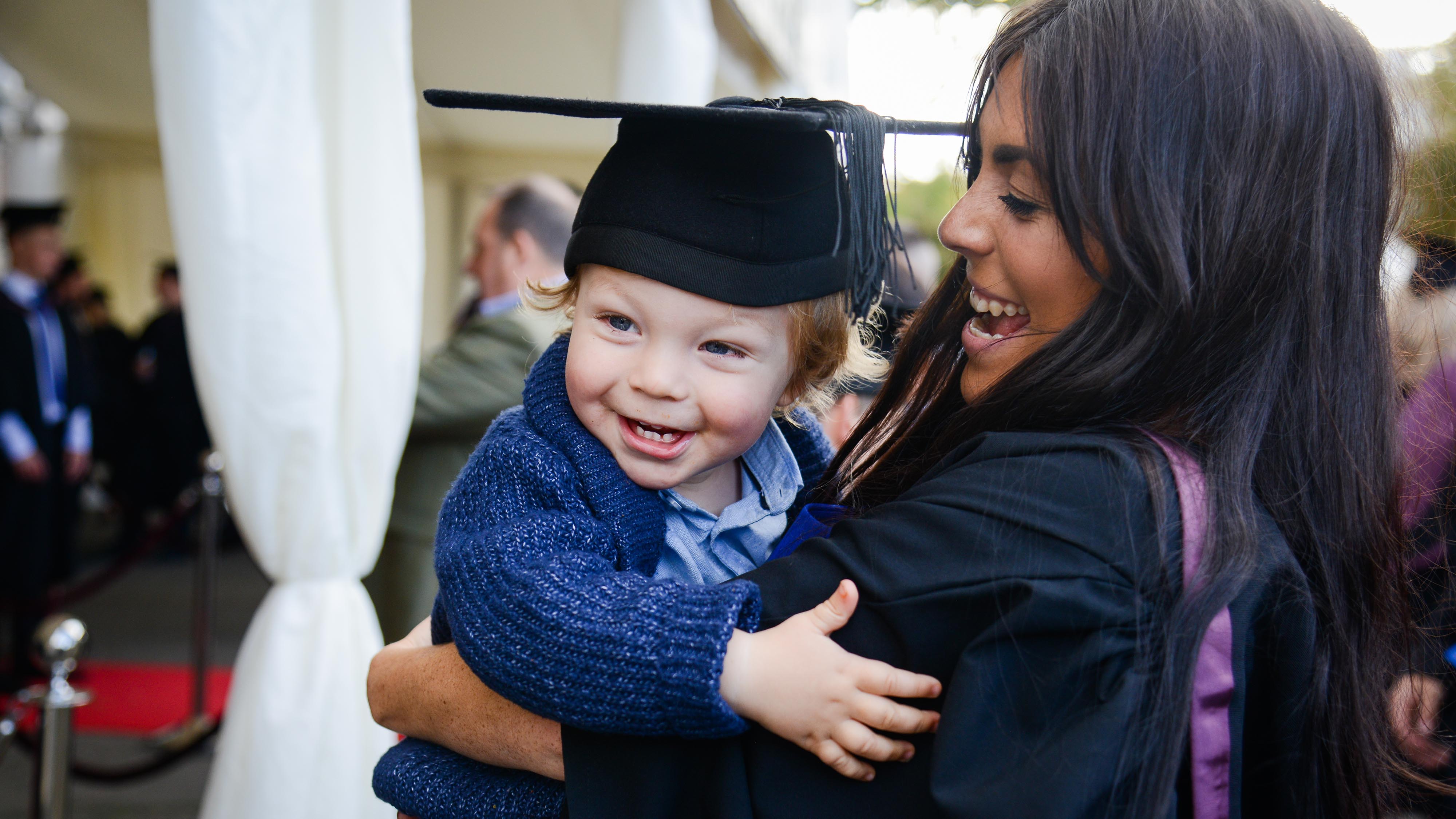 Child wears a graduation cap
