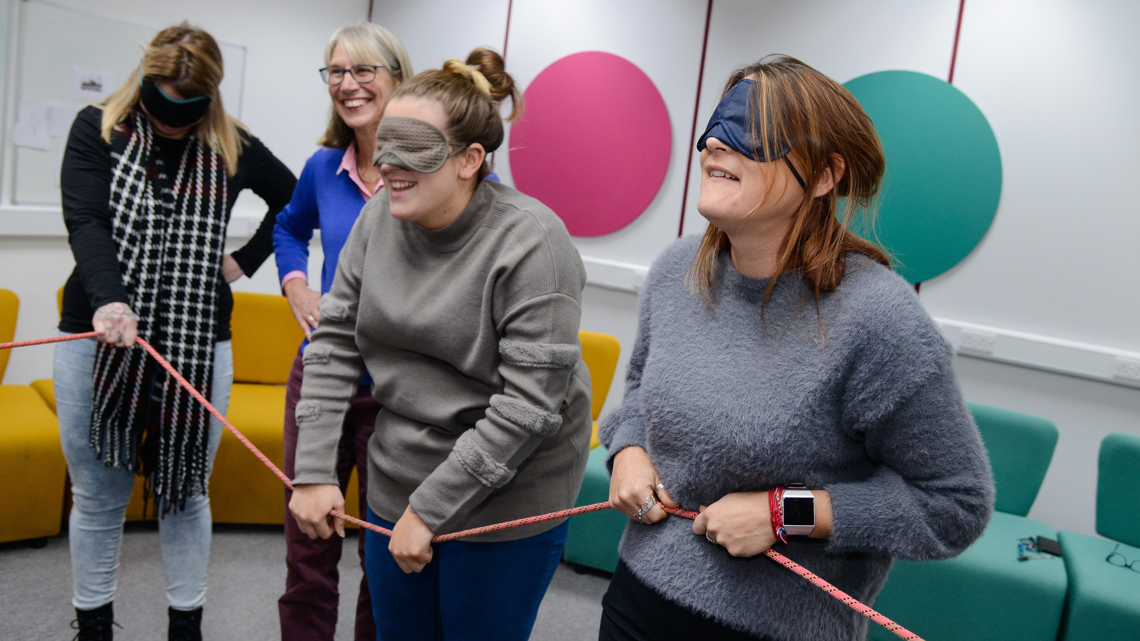 Students in blindfolds do a trust exercise